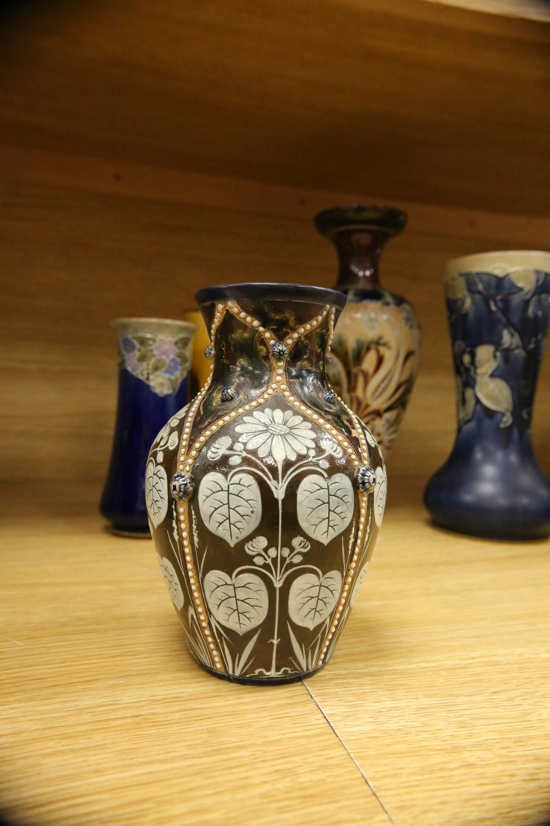 Four Royal Doulton vases and a yellow glazed jug items, tallest vase 34cm high. Condition - some crazing and faults, large vase has damage to lower neck